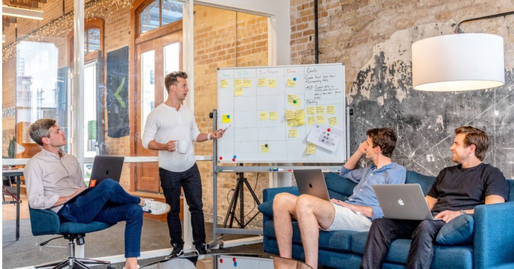 four guys looking at a whiteboard brainstorm session