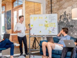 four guys looking at a whiteboard brainstorm session